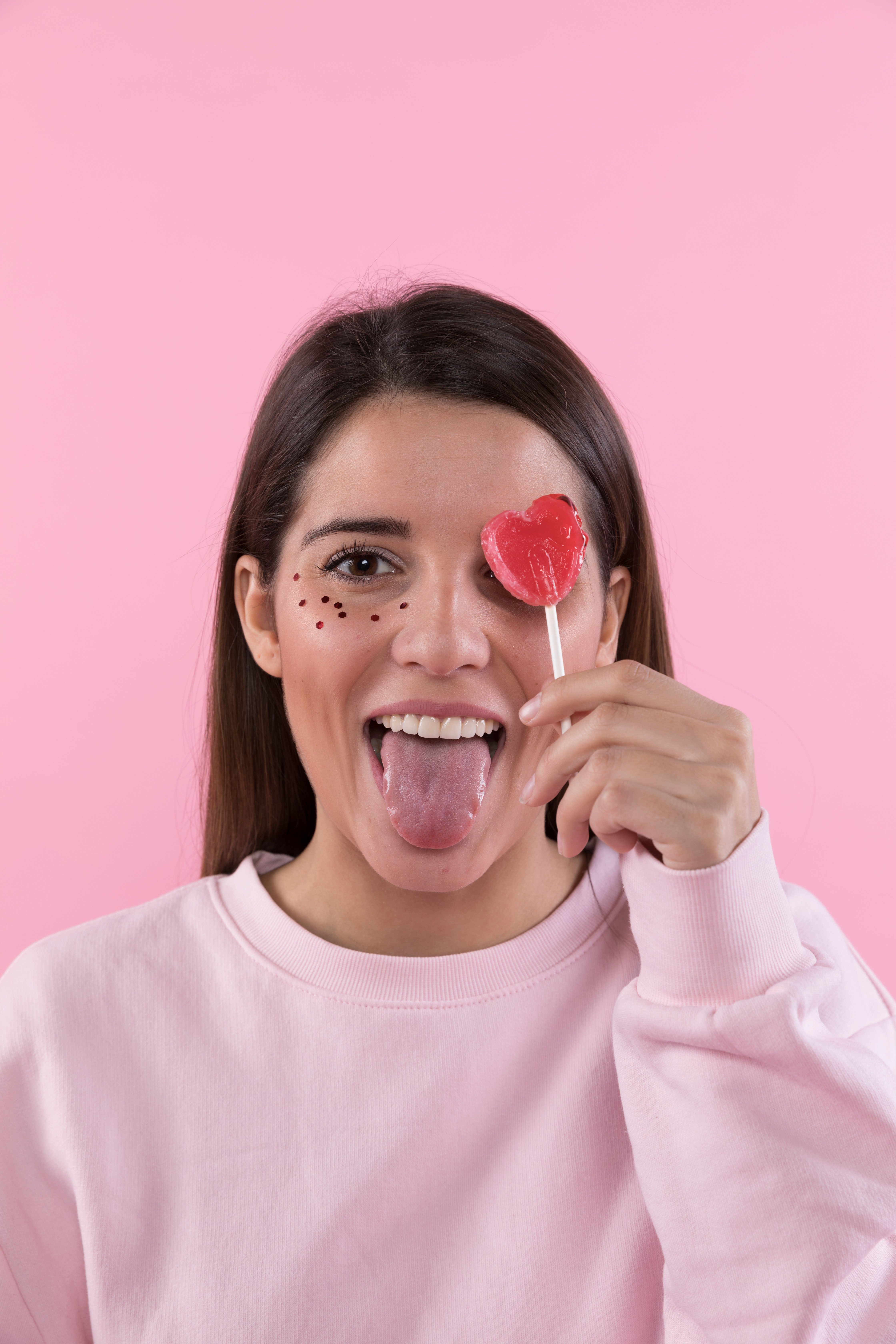young-lady-having-fun-with-ornament-glitters-face-lollipop (1)